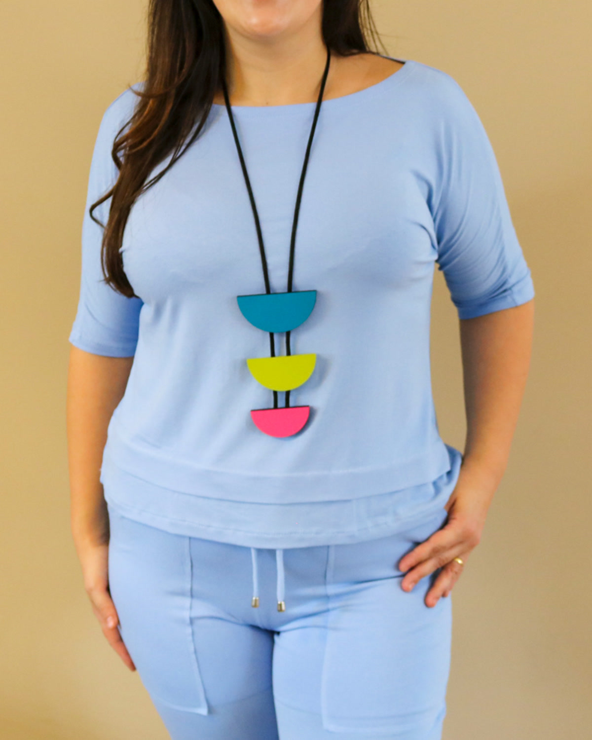 Colar Meia-Lua colorido usado sobre blusa azul lisa