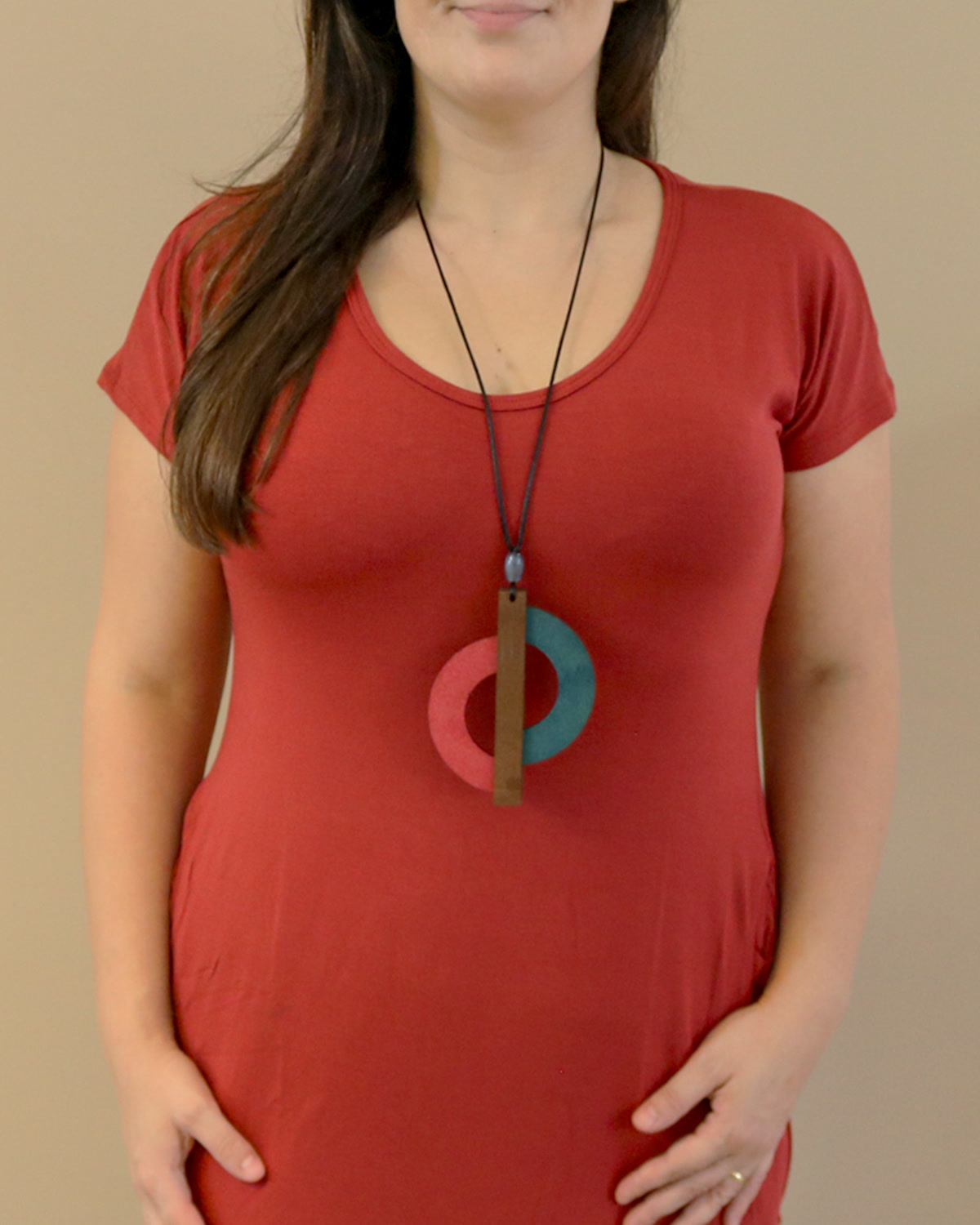 Mulher com blusa vermelha usando o Colar Semicírculos Azul/Rosa, com partes curvas coloridas